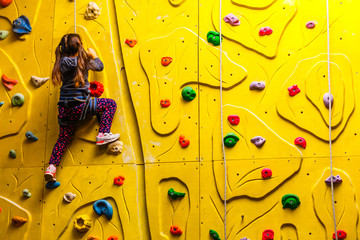 Little girl on climbing in entertainment center.