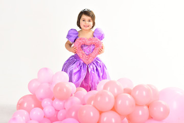 Fototapeta na wymiar Party balloons. Valentines day. Happy birthday. Kid fashion. Little miss in beautiful dress. Childhood and happiness. Childrens day. Small pretty child hold heart. Little girl princess. True love