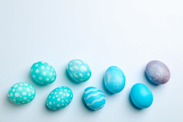Flat lay composition with Easter eggs on white background, space for text