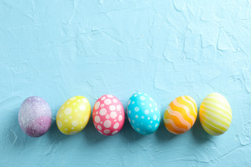 Decorative Easter eggs on color background, space for text. Top view