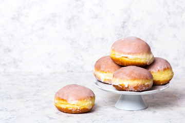 Traditional Polish donuts with frostng on light background. Tasty doughnuts with jam.