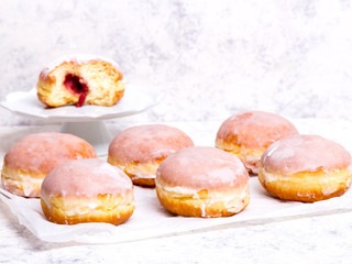 Traditional Polish donuts with frostng on light background. Tasty doughnuts with jam.