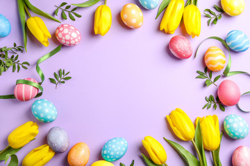 Flat lay composition with Easter eggs, tape and flowers on color background, space for text. Top view