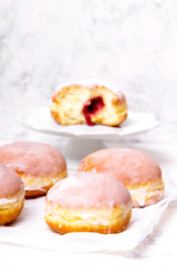 Traditional Polish donuts with frostng on light background. Tasty doughnuts with jam.