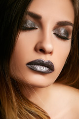Young brunette with beautiful dark makeup close-up