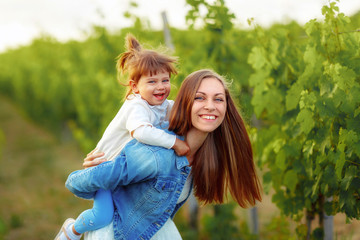 Fototapeta premium girl riding on the back of the mother in the green