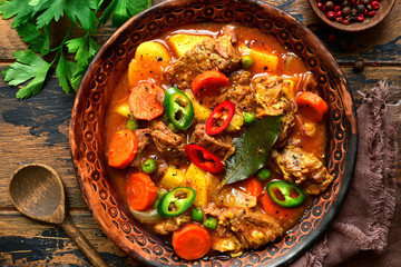 Meat stew with potato, carrot and green pea in a tomato sauce.Top view with copy space.