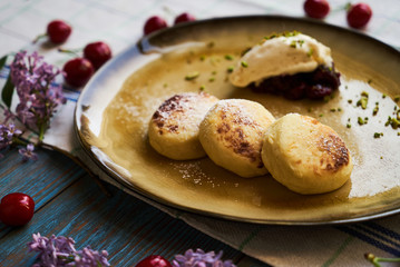 Cottage cheese pancakes, syrniki on rustic wooden table, close-up.
