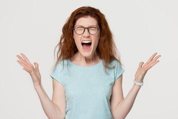 Angry mad redhead hysterical girl yelling shouting isolated on background
