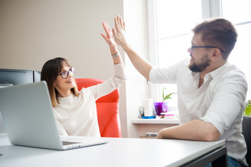 Happy business people team giving high five in office.