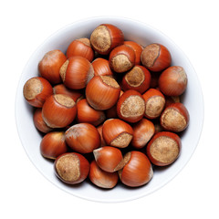 Hazelnuts with shell in bowl isolated on white background