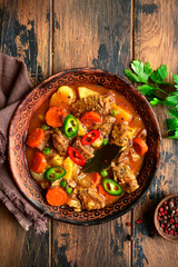 Meat stew with potato, carrot and green pea in a tomato sauce.Top view with copy space.