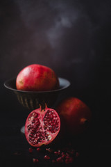 Still life of pomegranates against a dark background