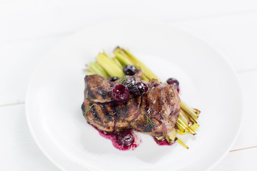 Big slice of steak with sauce of cherry berries with vegetables. Menu, food photo concept