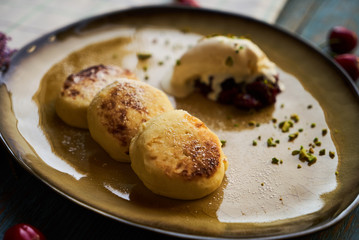 Cheesecake with cherry ice cream, sour cream, pistachios and mint leaves