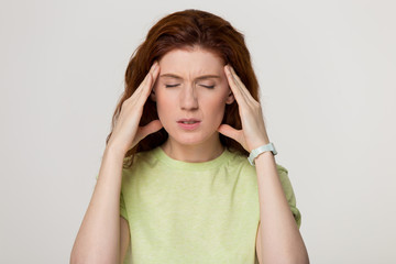 Stressed redhead woman feel strong headache isolated on blank background