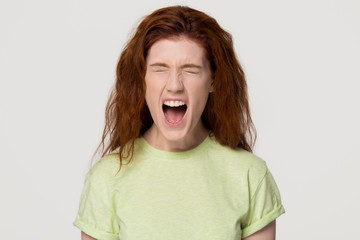 Angry stressed redhead woman screaming yelling loud isolated on background