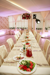 A cozy banquet room during a wedding celebration. Served table decorated with a beautiful bouquet of flowers
