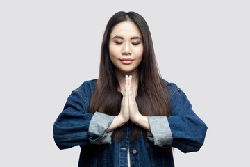 Portrait of calm beautiful brunette asian young woman in casual blue denim jacket with makeup...