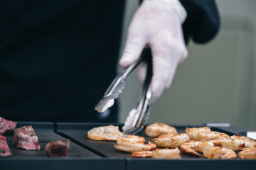 Cook prepares grilled shrimp