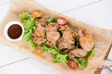 Grilled chicken  with salad,tomatoes and sauce on wooden table