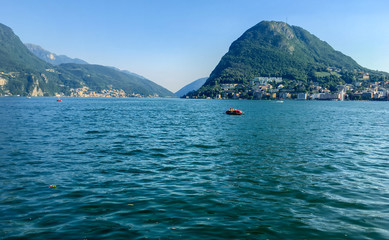 Ufer des Luganersee (Lake Lugano) im Tessin, Schweiz. Blick auf die Berge und blauer Himmel