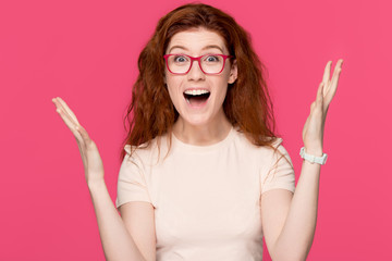 Happy redhead young woman feeling winner isolated on pink background
