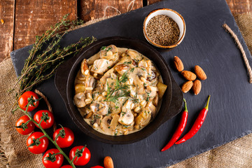 Mushrooms in cream sauce, julienne. Champignon on a black slate background