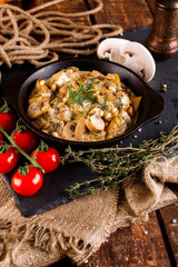 Mushrooms in cream sauce, julienne. Champignon on a black slate background