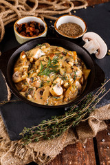 Mushrooms in cream sauce, julienne, champignon, products for cooking on the background of shale black Board