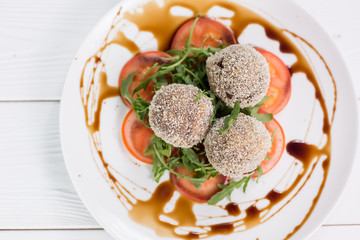 Fresh salat with tomatoes, rucola and meat rolls with sauce