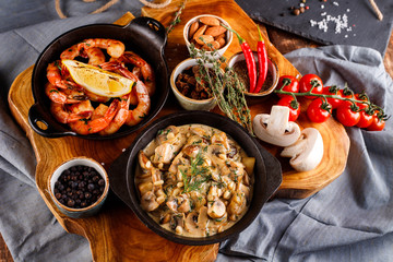Fried large shrimp in tomato sauce with olive oil,Mushrooms in cream sauce, julienne, champignon, products for cooking