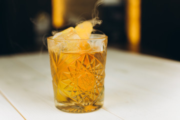 Colorful drink with fresh fruits in glass cup on white wooden background