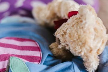 Close up of a toddler girl sleeping with a stuffed teddy bear