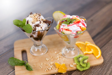 Ice cream with chocolate and fresh friuts on wooden table