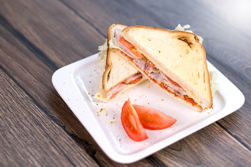 Sandwich with meat and tomatoes on white plate. Breakfast, lunch concept