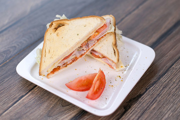 Sandwich with meat and tomatoes on white plate. Breakfast, lunch concept