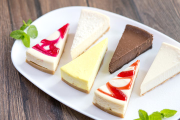 Slices of various cheese cakes on white plate. Sugar desserts, food concept 
