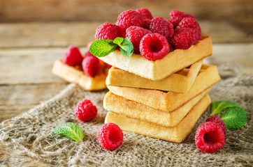 Waffeles with berries and mint leaf on a wood background