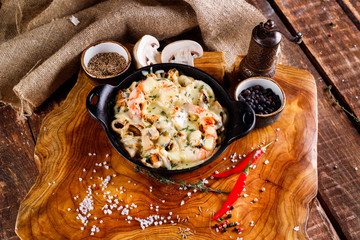 Delicious seafood in white sauce on a metal black plate, a number of products for cooking,...