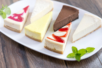 Slices of various cheese cakes on white plate. Sugar desserts, food concept 