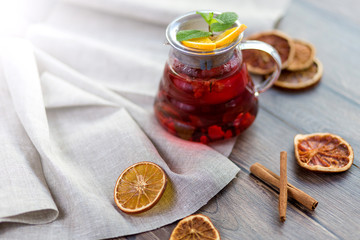 Citrus vitamin natural organic hot tea with berries and citrus fruits in glass spot with cups