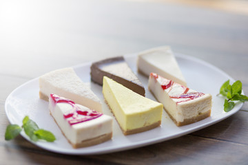 Slices of various cheese cakes on white plate. Sugar desserts, food concept 