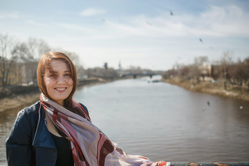 Pretty girl in a scarf and leather jacket in spring city. Concept of spring, freedom, travel and...