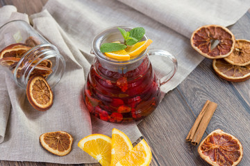 Citrus vitamin natural organic hot tea with berries and citrus fruits in glass spot with cups