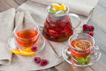 Citrus vitamin natural organic hot tea with berries and citrus fruits in glass spot with cups
