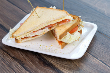 Sandwich with tomatoes and bacon on plate. Breakfast, food phto concept