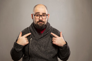 Young bald man surprised, gray background