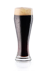 Cold dark beer with drops and foam in glass. isolated