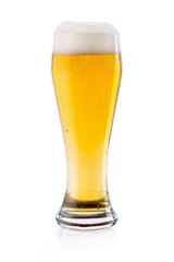 Cold light lager beer with drops and foam in glass. isolated